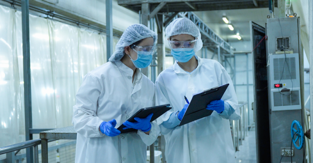 Life sciences workers review inventory records in a controlled GMP environment.