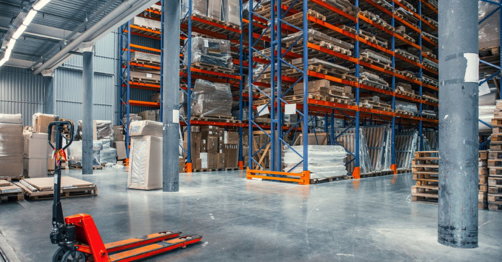 Warehouse aisle with tall pallet racking, pallet jack, and palletized inventory stored on shelving