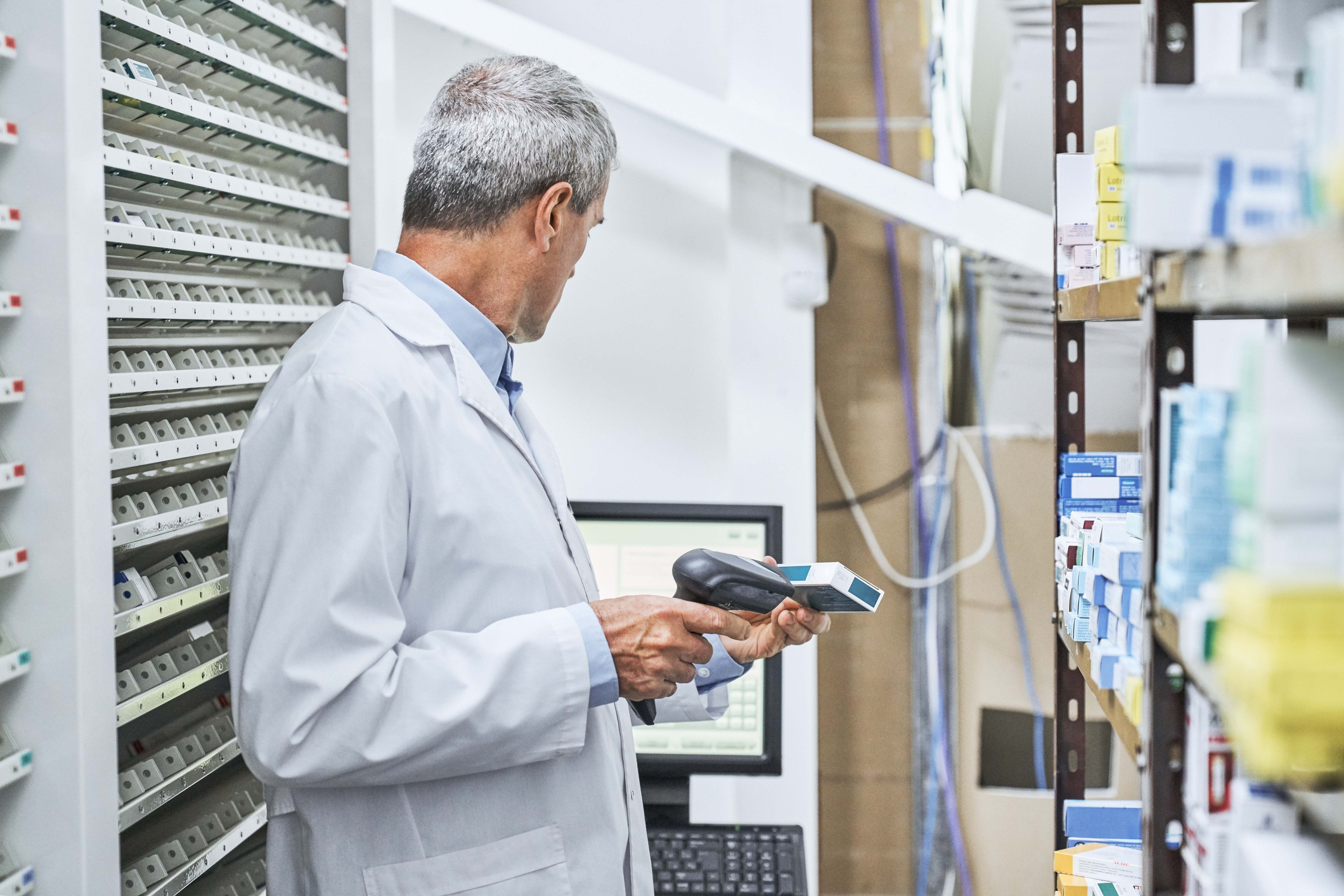 Worker managing regulated inventory in a life sciences warehouse.