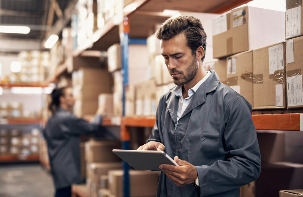 Shot of a young man using a digital tablet while working in a warehouse