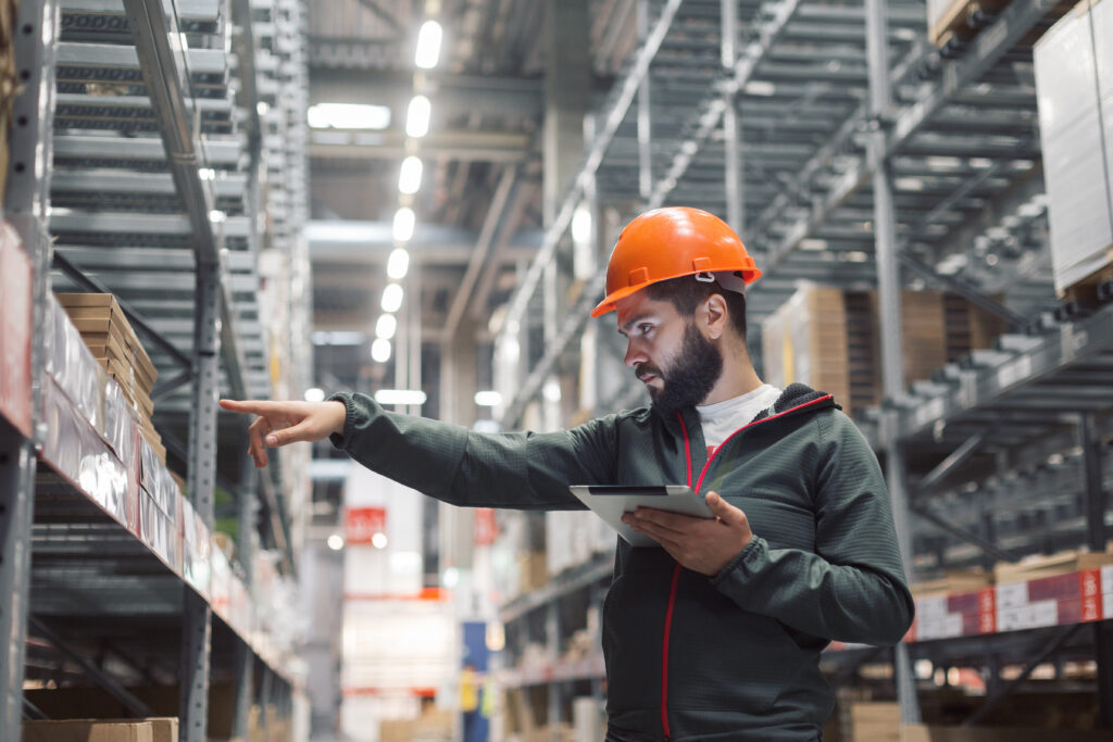 Workers operating forklift and handling palletized inventory inside refrigerated cold storage warehouse