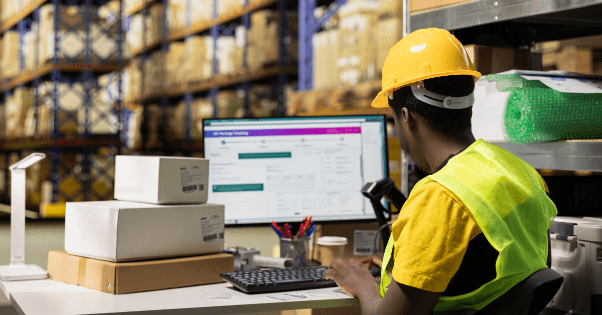 Blog #11 3PL Growth in 2026 How WMS Technology Becomes Your Competitive Advantage user of warehouse management system for 3PL growth seated at desktop in large fulfillment cente