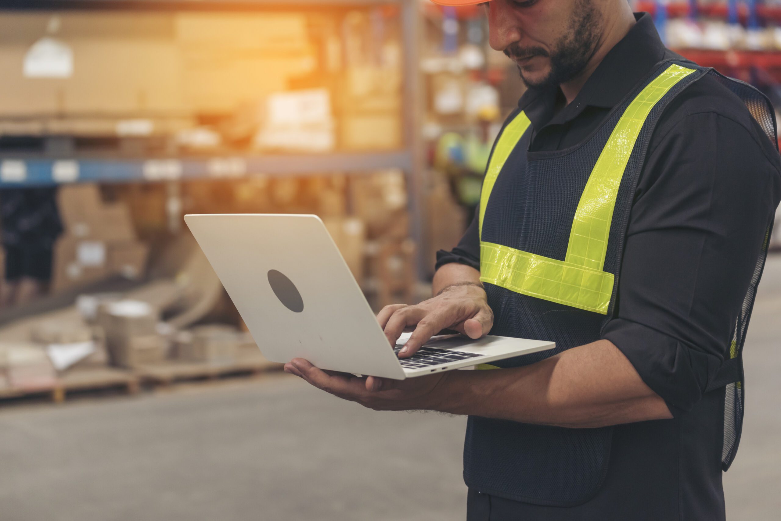 Hispanic men hands using typing laptop computer Warehouse management logistics counting checking products on inventory shelf. Engineer Man hands checklist stock control computer program in storage